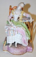 Lot 252 - A Dresden porcelain figurine of a seated...