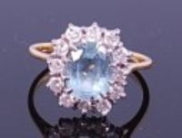 Lot 1243 - An 18ct gold, aquamarine and diamond cluster...