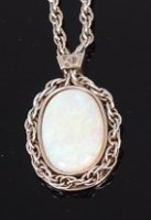 Lot 1245 - A 9ct white gold and opal set pendant, the...