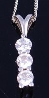 Lot 1266 - An 18ct white gold diamond pendant, arranged...