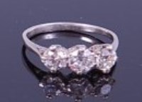 Lot 1279 - A platinum diamond three stone ring, arranged...