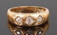 Lot 1294 - An 18ct gold 'gypsy' style three stone ring,...