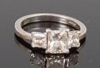 Lot 1309 - A platinum diamond three stone ring, arranged...