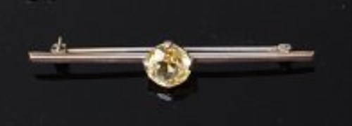 Lot 2009 - An 18ct white gold and yellow sapphire set bar...