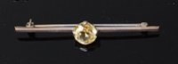 Lot 2009 - An 18ct white gold and yellow sapphire set bar...