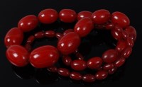 Lot 2082 - A beaded cherry amber necklace, comprising 52...