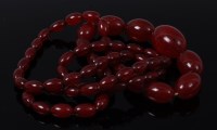 Lot 2115 - A beaded and graduated cherry amber necklace,...