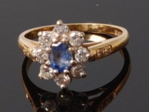 Lot 2036 - An 18ct gold, sapphire and diamond set flower...