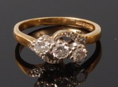 Lot 2037 - An 18ct gold diamond three stone ring, the...