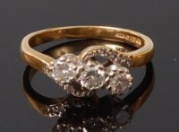 Lot 2037 - An 18ct gold diamond three stone ring, the...