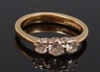Lot 2211 - An 18ct gold diamond three stone ring, the...