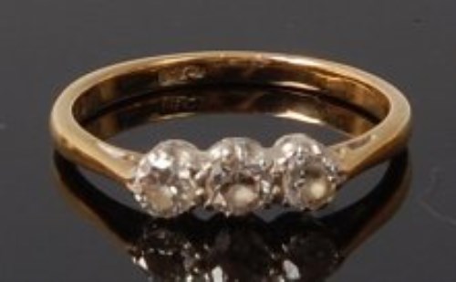 Lot 2046 - An 18ct gold diamond three stone ring, the...