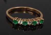 Lot 2263 - A 9ct gold, emerald and diamond ring, arranged...