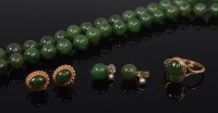 Lot 2303 - A beaded spinach jade necklace, on single...