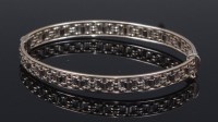 Lot 2313 - A contemporary 9ct white gold hinge bangle, 13....