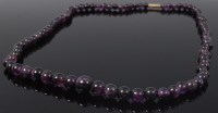 Lot 2150 - A beaded and graduated amethyst single string...