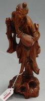 Lot 230 - A Chinese stained softwood carving of a...