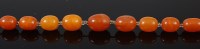 Lot 2275 - A beaded butterscotch amber single string...