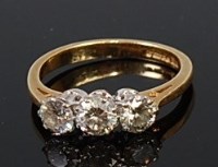 Lot 2122 - An 18ct gold and diamond three stone ring, the...