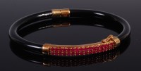 Lot 2370 - A black onyx 9ct gold and ruby set hinged...