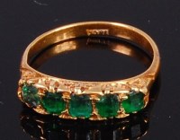 Lot 2050 - An 18ct gold and emerald set dress ring...