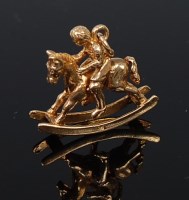 Lot 2091 - A 9ct gold charm modelled as a child upon a...
