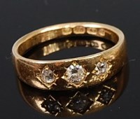 Lot 2186 - An 18ct gold diamond three stone ring, the...