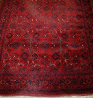 Lot 1520 - A Persian woollen red ground rug, decorated...