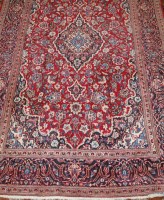 Lot 1524 - A Persian woollen Kashan rug, the red ground...