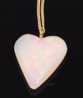 Lot 1190 - A polished opal heart shaped pendant,...