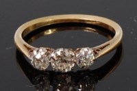 Lot 1192 - An 18ct gold and diamond three stone ring, the...