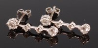 Lot 1215 - A pair of 18ct white gold and diamond drop ear...