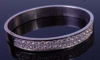 Lot 1274 - An 18ct white gold and diamond set bangle,...