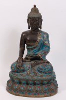 Lot 1411 - A Tibetan hollow bronze and enamel seated...