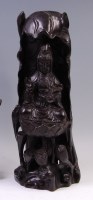 Lot 1413 - A Chinese hardwood carving of Guanyin, in...