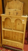 Lot 1455 - A modern pine hanging wall shelf having twin...