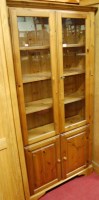 Lot 1206 - A modern pine double door glazed bookcase,...