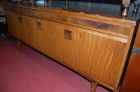 Lot 1240 - A 1960s teak long sideboard, having three...