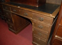 Lot 1259 - An Edwardian oak and rexine inset kneehole...