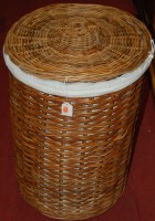 Lot 1262 - A wicker circular laundry basket and cover