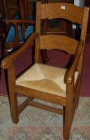 Lot 1386 - A joined oak rush seat elbow chair, together...