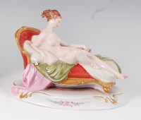 Lot 1057 - A Dresden porcelain figure of a reclining...