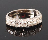 Lot 1217 - An 18ct gold and diamond half eternity ring,...