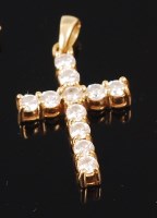 Lot 1256 - An 18ct gold diamond set cross pendant, the...