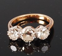 Lot 1287 - An 18ct gold and diamond three stone ring, the...