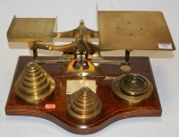 Lot 184 - A set of Victorian brass postal scales on oak...