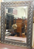 Lot 1027 - Carved and ebonised oak framed bevelled wall...