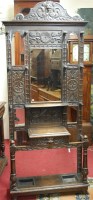 Lot 1115 - A circa 1900 heavily carved oak mirrorback...