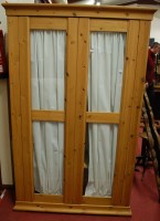Lot 1163 - A modern pine double door glazed freestanding...