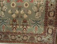 Lot 1174 - A Persian woollen green ground rug, the...